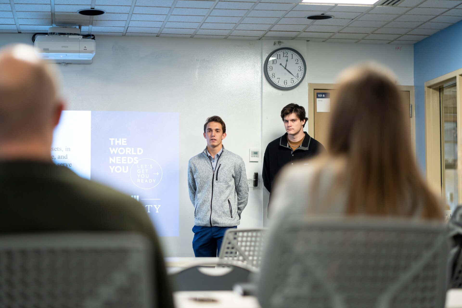 Student standing while presenting with peers